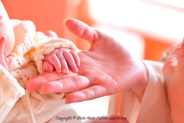 赤ちゃんの初宮参り・お宮参りの出張写真イメージ撮影。ママの指に手を置く小さな赤ちゃんの手。