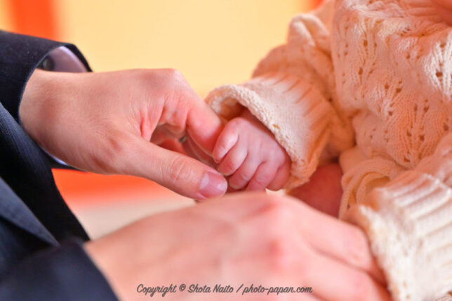 赤ちゃんの初宮参り・お宮参りの出張写真撮影。パパの指をきゅっと握る小さな赤ちゃんの手。