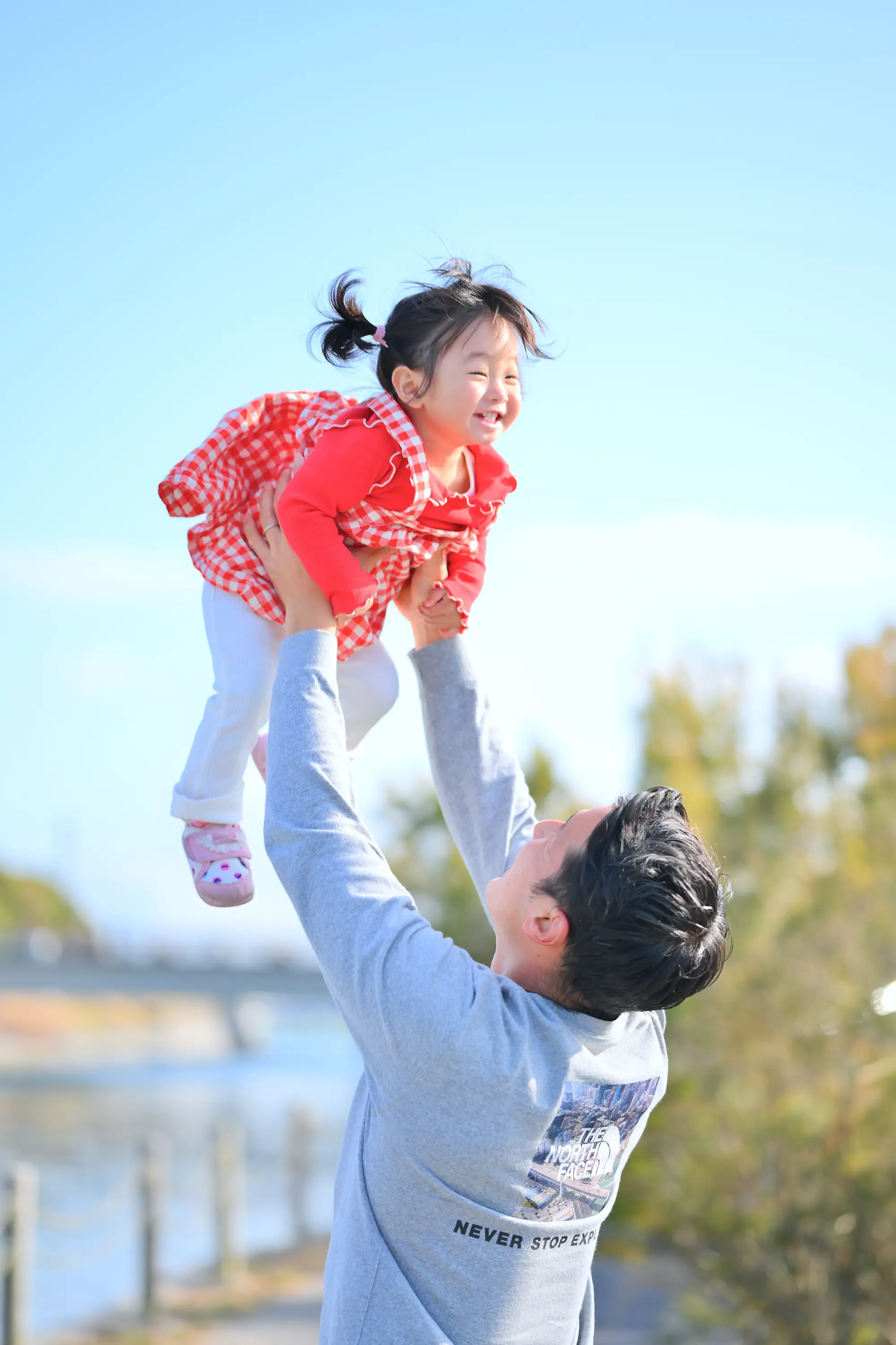 高い高いで喜ぶ女の子とパパのファミリーフォト